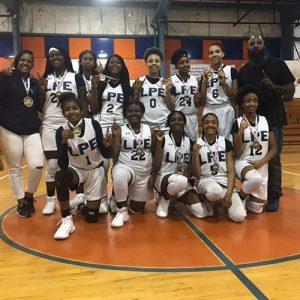 Coach Fallon Buckner posing with basketball team.