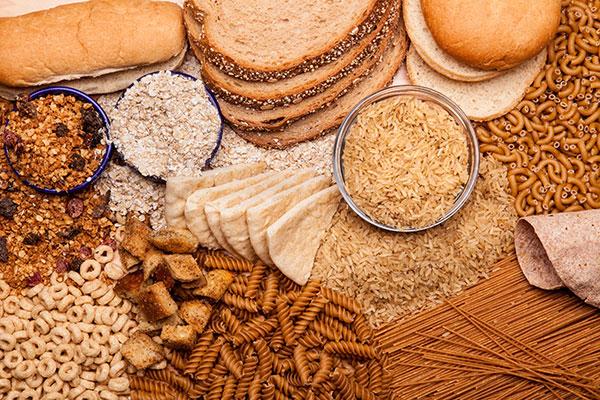 a variety of breads and whole grains including pasta on table