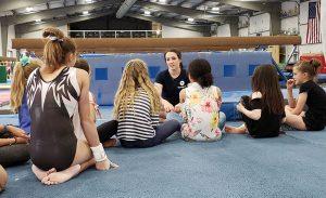 chellsie memmel sitting and talking to young gymnast athletes