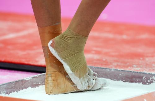 Close up of a female gymnasts feet in chalk.