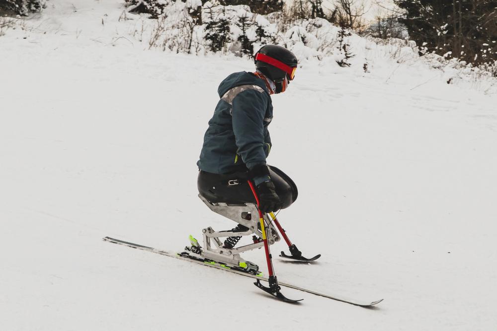 Man with leg amputations skiing on modified ski.
