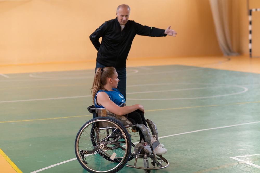 Wheelchair basketball athlete with coach.