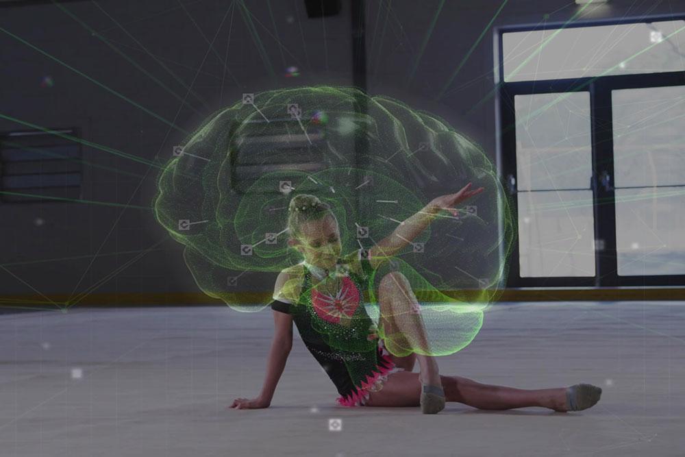 Graphic of a brain over a young female gymnast doing a floor routine.