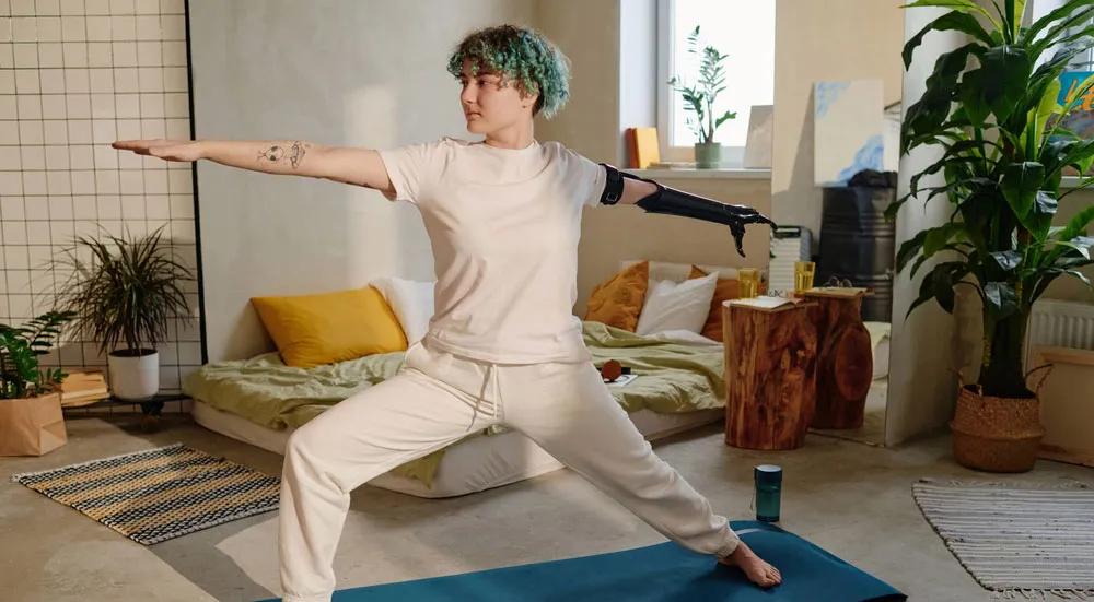 Young woman with arm aputation doing yoga.