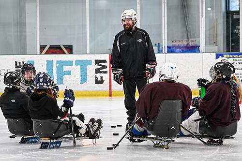 Sled hockey team with coach.