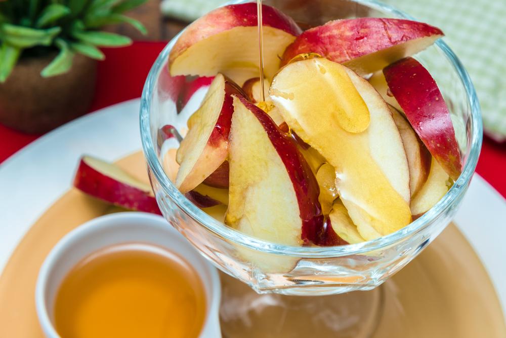 Sliced apples with honey drizzled on them.