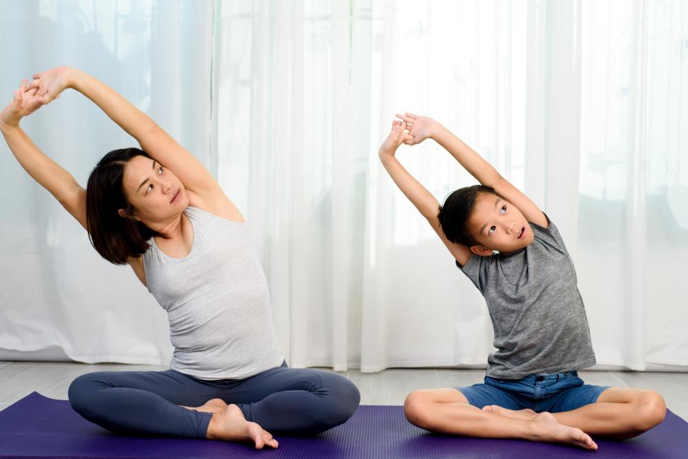 Mother and son doing yoga next to each other.