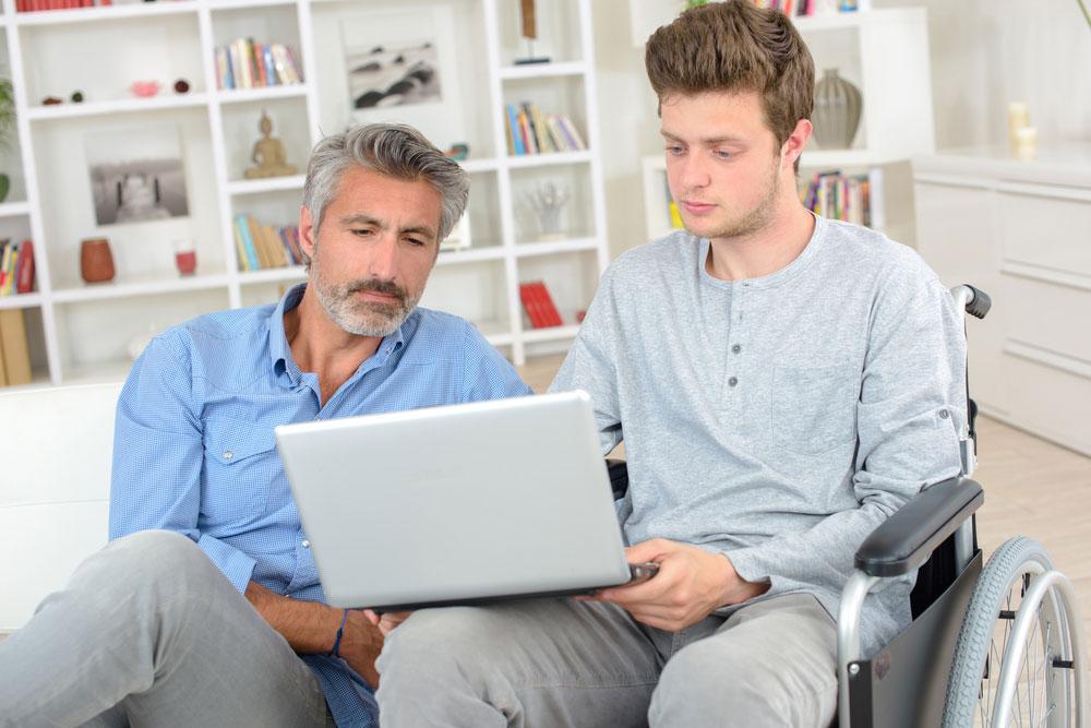 Father and son on laptop together.