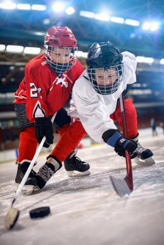 Two young boys playing ice hockey.