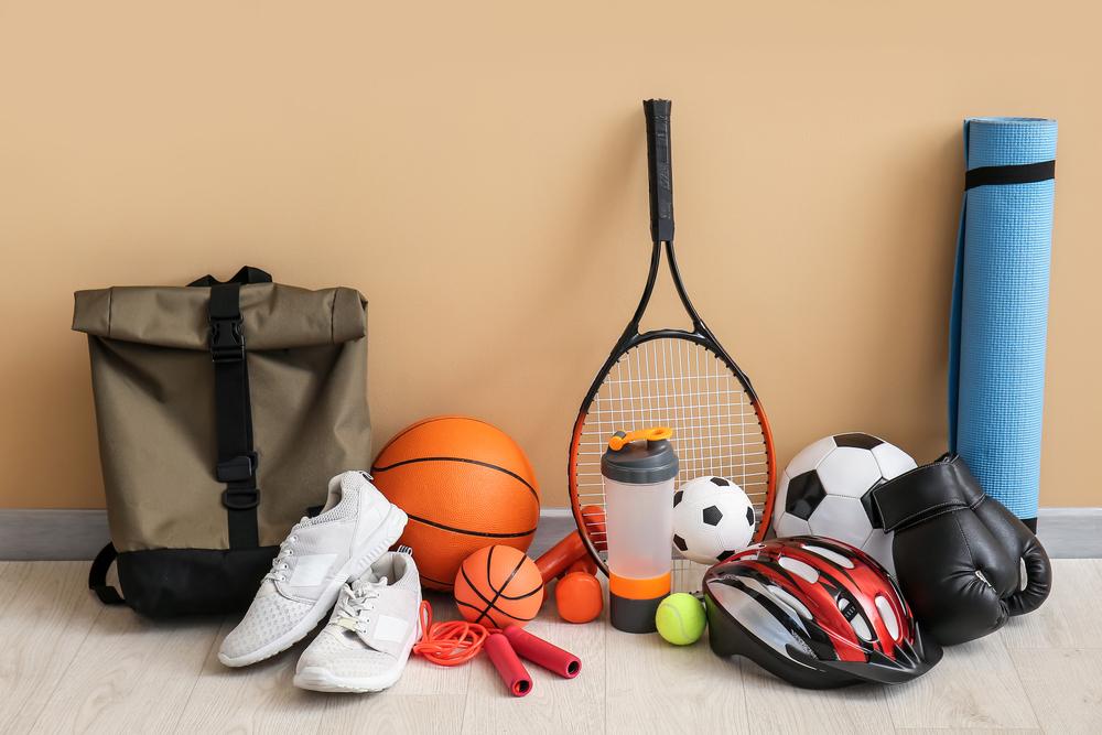 A variety of different sports equipment on the floor.