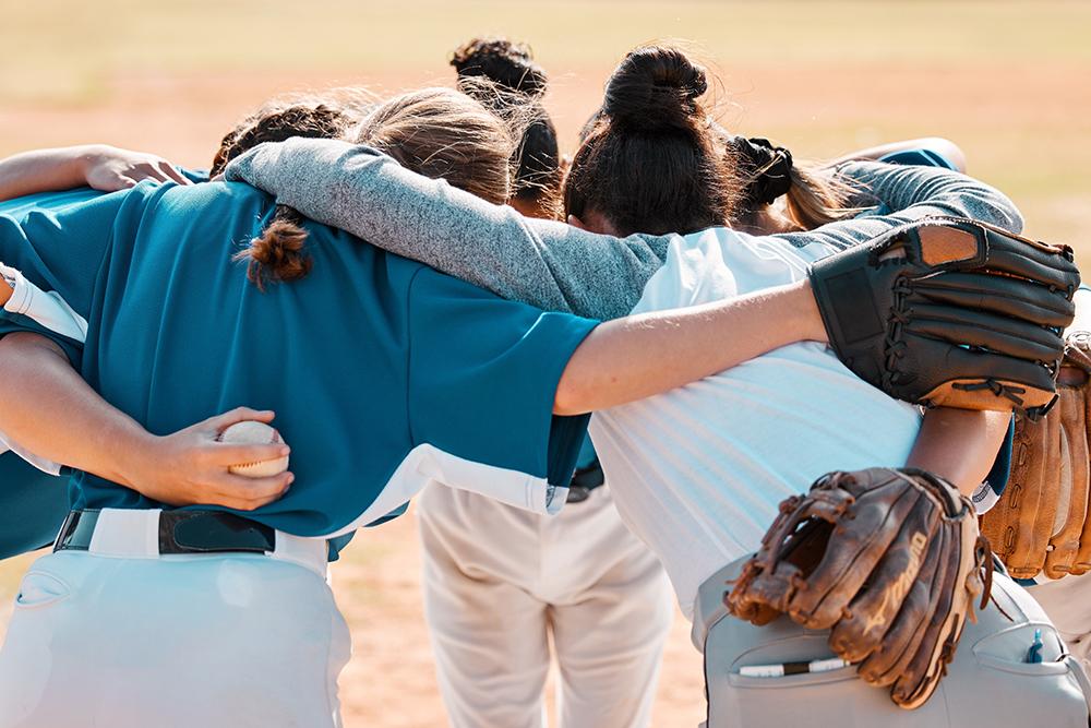 Girl's softball team in a huddle.