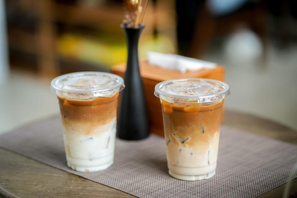 Two iced coffees with milk prepared to-go.