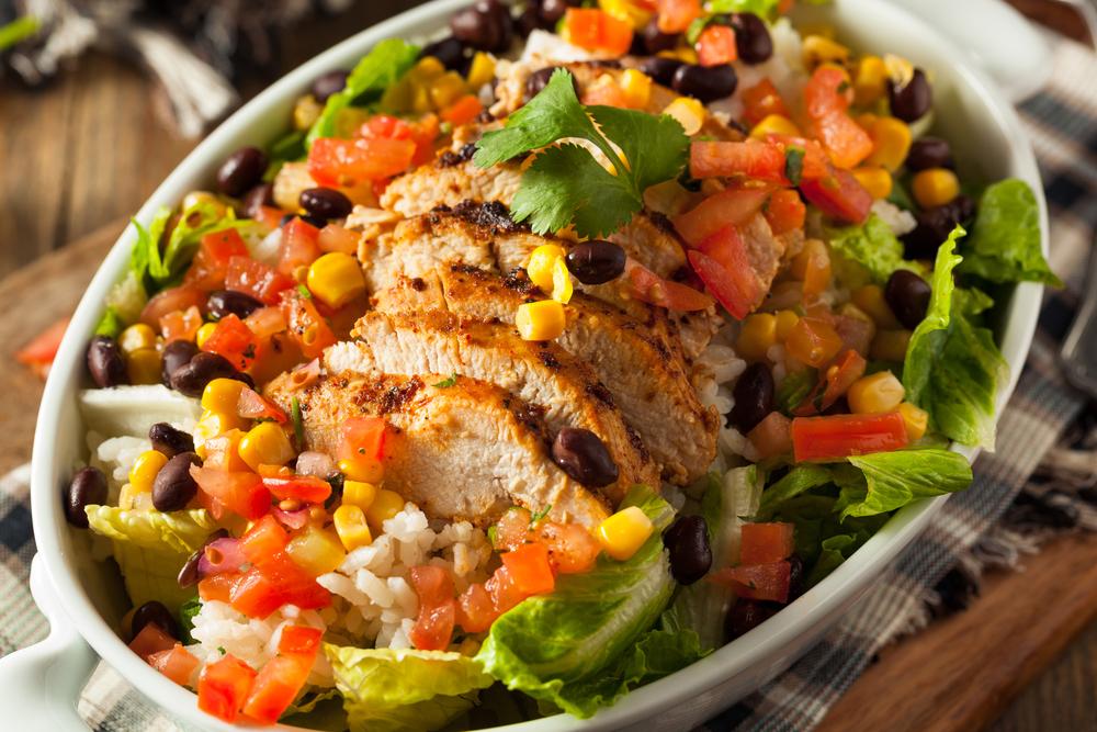 A chicken burrito bowl with rice and vegetables.