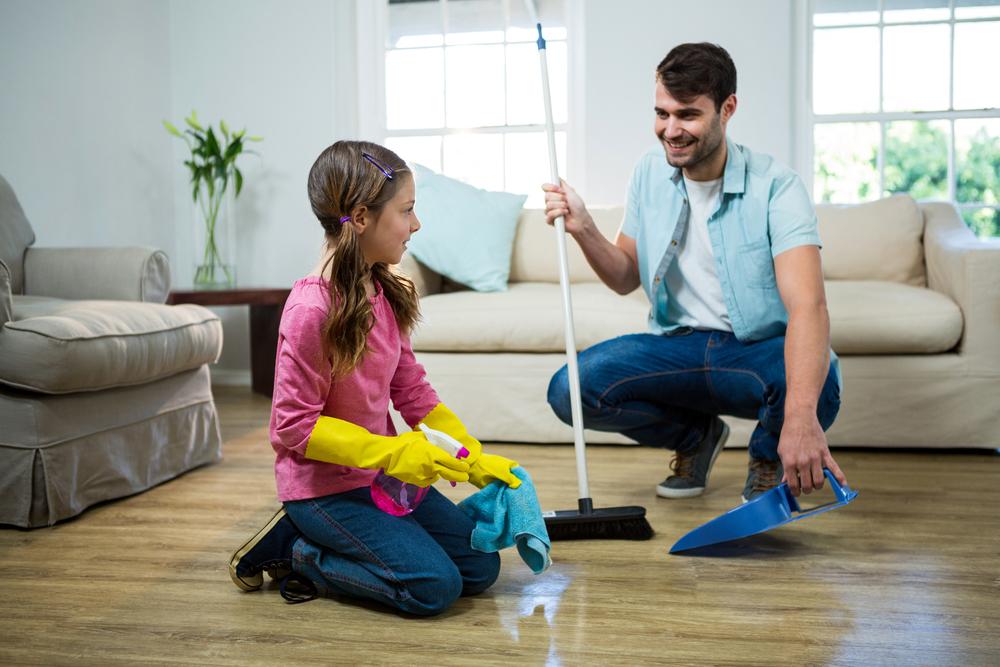 Father and daughter cleaning in house.