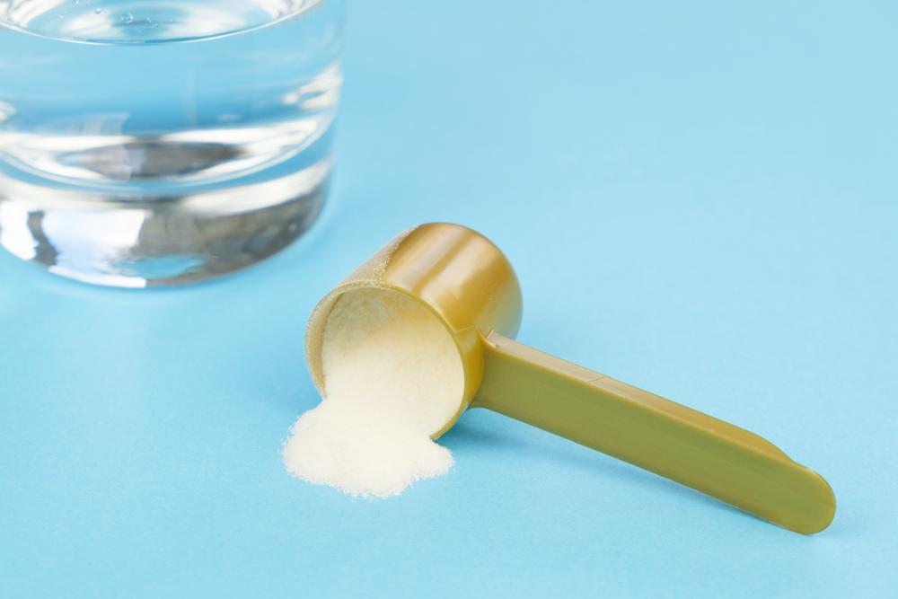 Collagen powder next to glass of water.