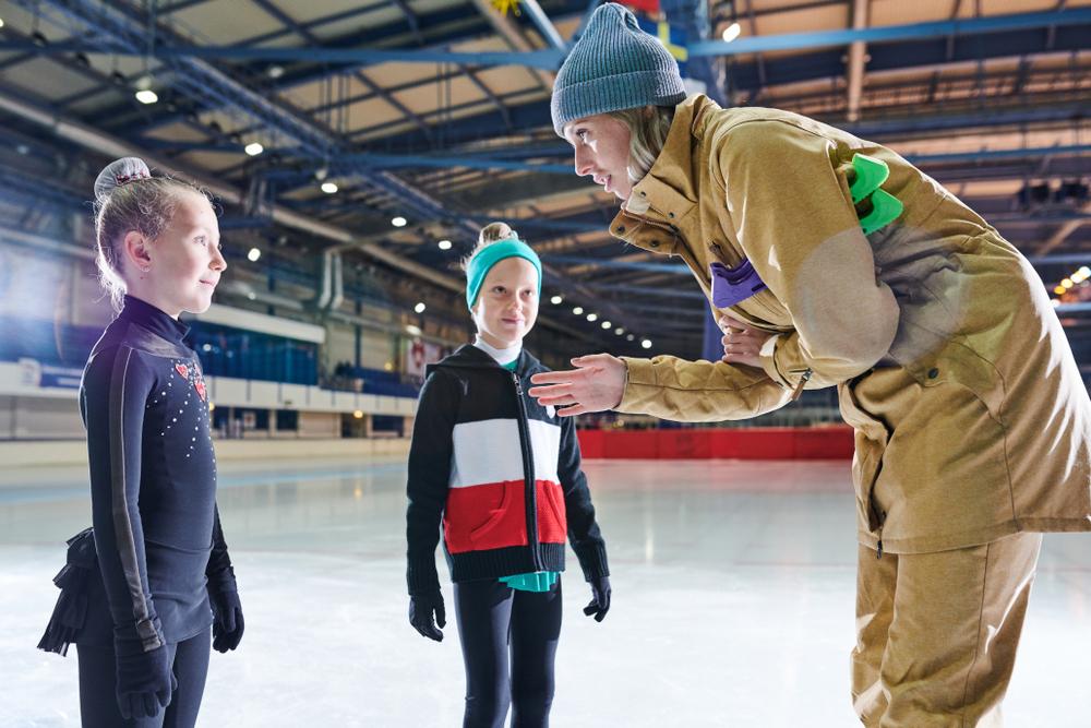 Figure skating coach talking to young athlete.