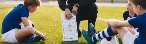 Coach sharing plays with soccer team.