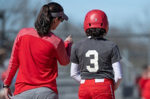 Softball coach talking to young player.