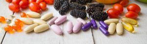 colorful supplements on table with fruit and vegetables