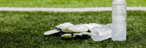 water bottle and soccer gloves on field