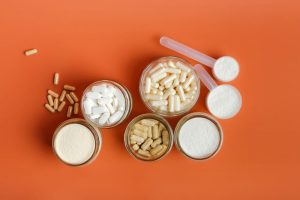 A variety of pills and powders against an orange background.