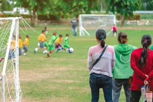 Parents on sideline at a youth soccer game.