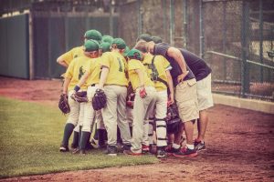 Young baseball team with coach in a huddle.