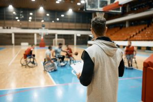 A coach watching a wheelchair basketball practice.