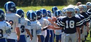 Young football players high fiving with another team after a game.