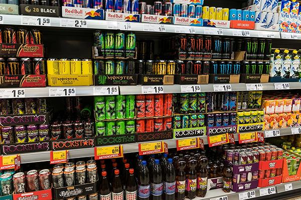 Store shelves full of canned energy drinks.
