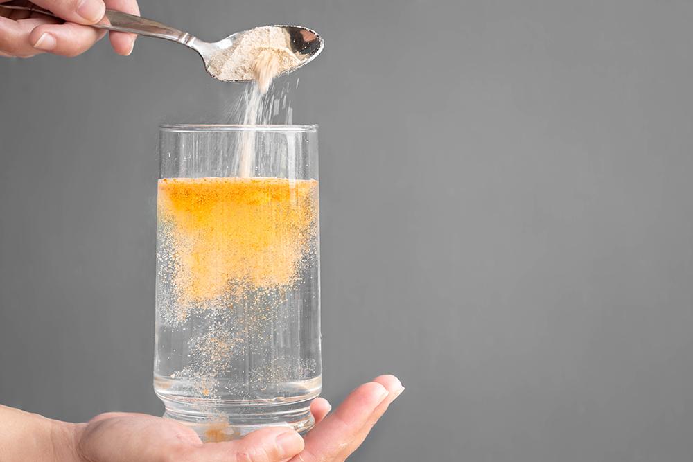 Powder being put into a glass of water.