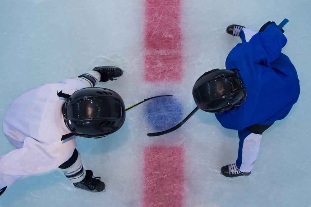 Two young hockey players during a face off.