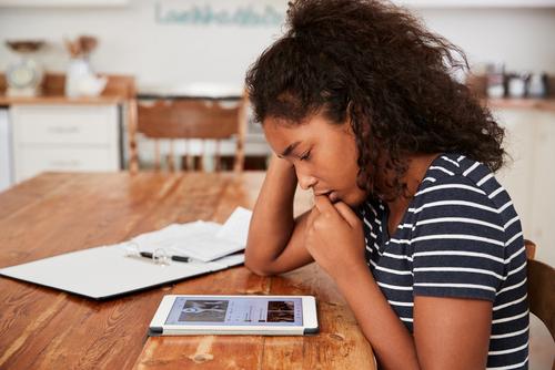 young girl on tablet looking concerned.