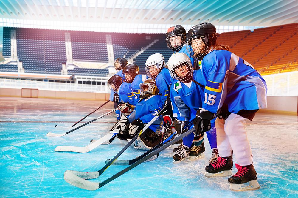 Young female hockey team together on ice.