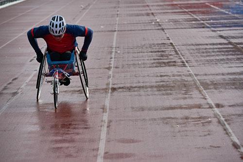 hand cyclist on wet track.