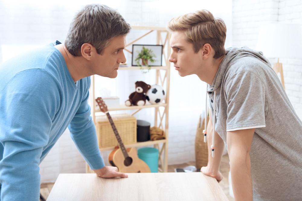Father and son in argument with a soccer ball in the background.