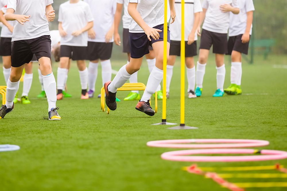 Young soccer team doing training drills outside.