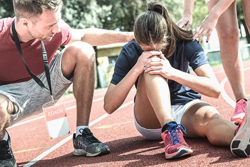 Teen girl injured on track with coach.