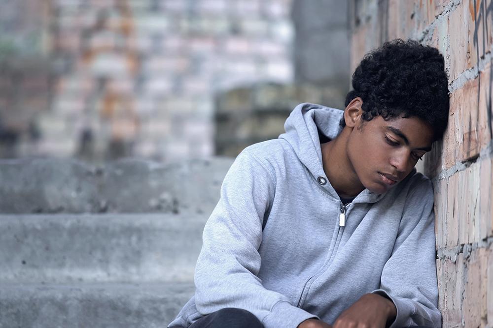 Depressed young man sitting on stairs.
