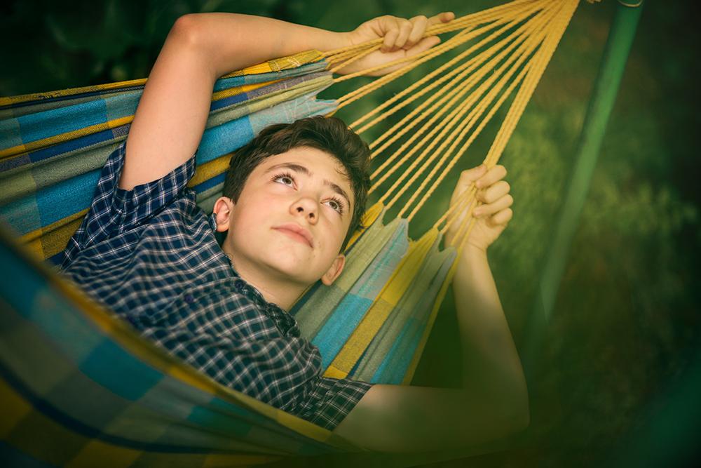 Boy in hammock looking up.