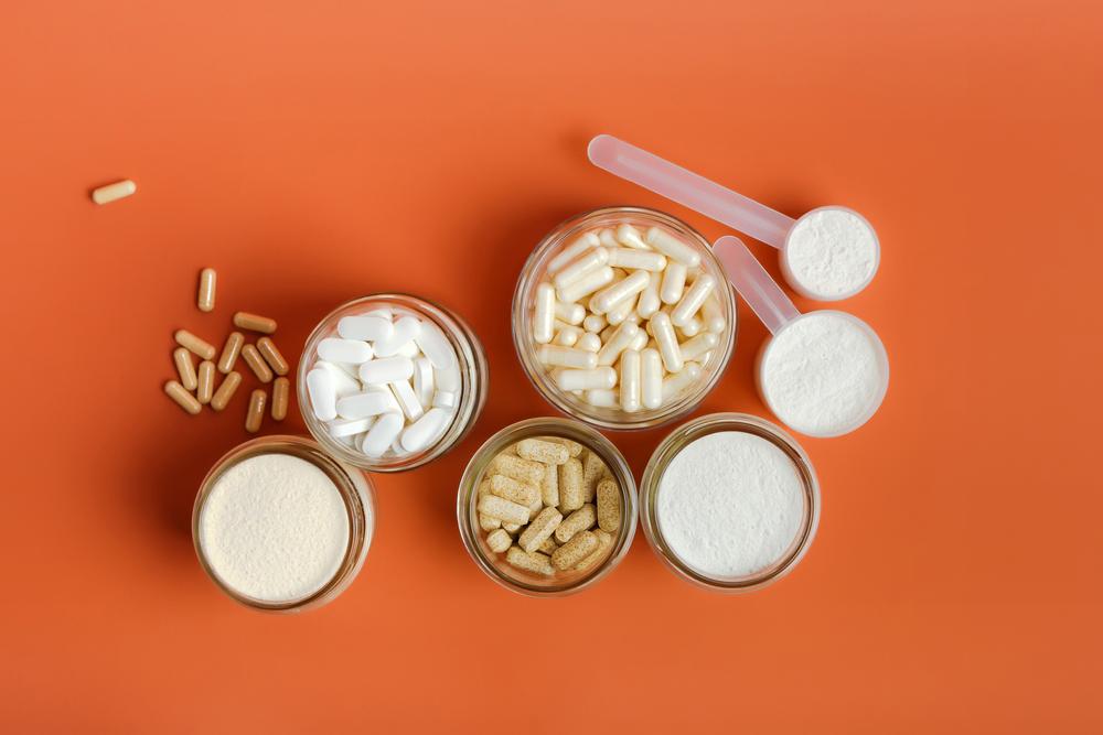 A variety of pills and powders against an orange background.