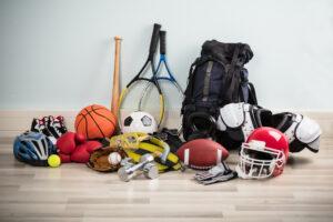 Variety of sport equipment on a floor.