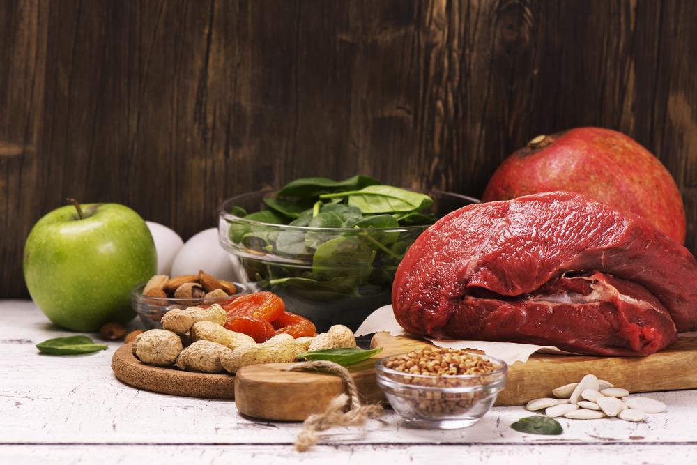 A variety of iron-rich foods including red meat, dark, leafy greens, and beans.