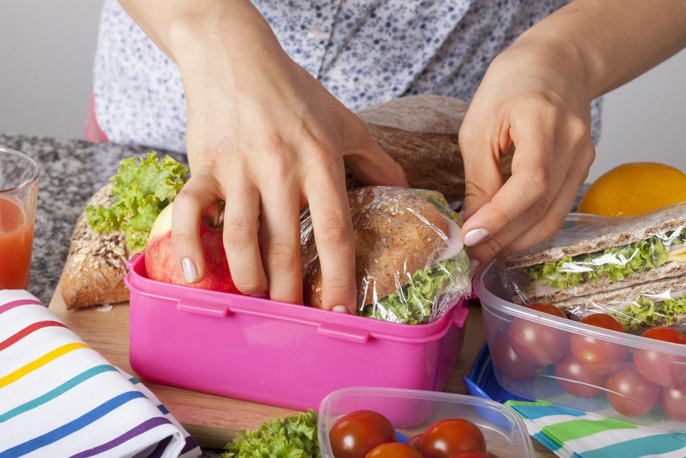 Close up of hands packing a lunch.