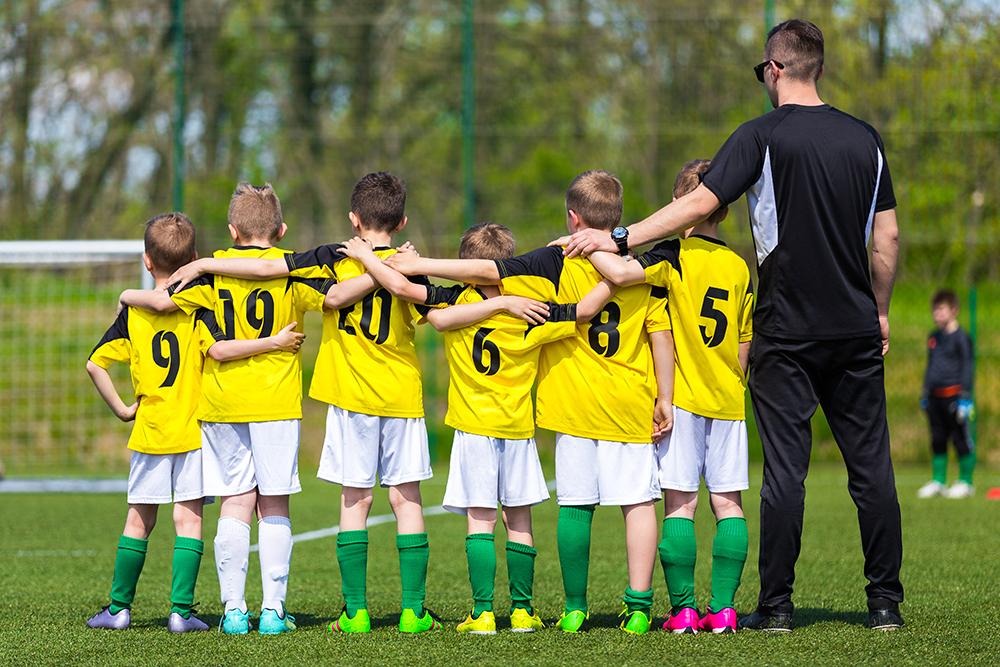 Young soccer team with arms around each other.