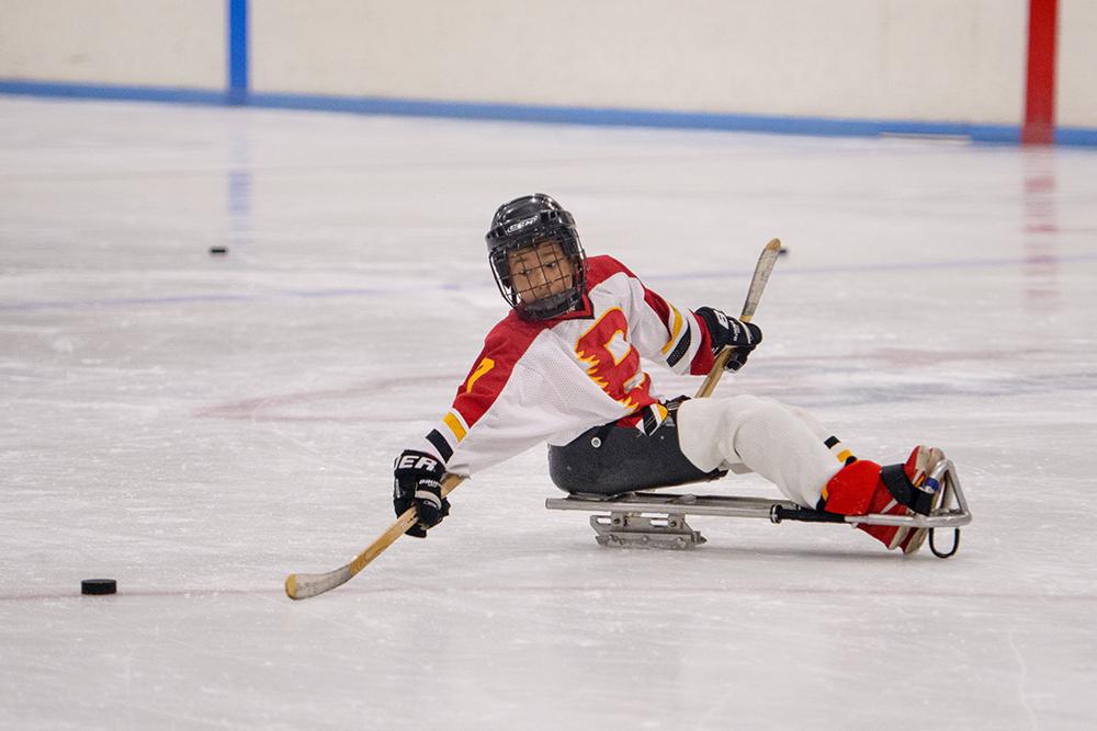 Young male sled hockey player on ice.