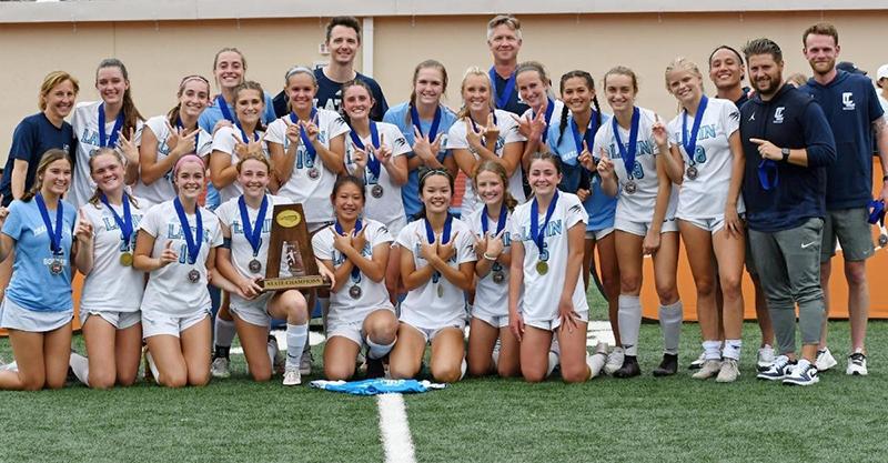 Coach Powell Paguibitan posing with the Charlotte Latin School state championship girls soccer team.