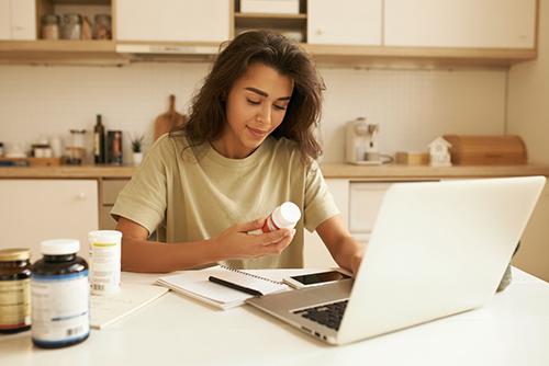 Woman reading a supplement facts label.