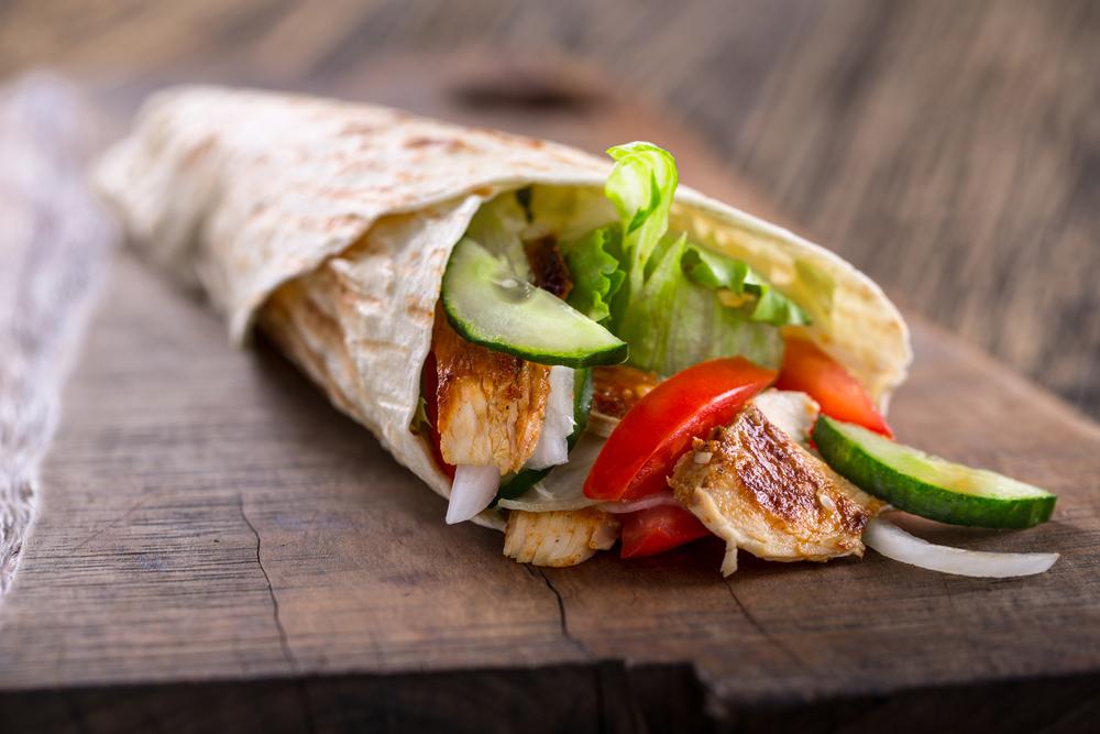 Close up of a chicken wrap with vegetables.
