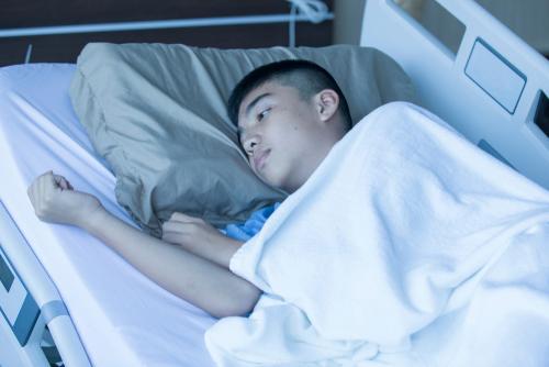 Young hispanic boy in hospital bed.